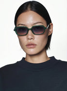 Hayden Green Jungle Sunglasses modeled by a person wearing dark clothing, featuring unique eco-friendly design.