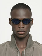 Doris Black Sunglasses worn by a model, featuring blue lenses and stylish design, showcasing unisex UV 400 protection.