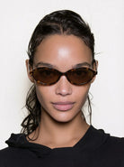 Doris Havana Amber Sunglasses worn by a model with a sleek hairstyle, featuring a stylish amber tortoiseshell design.