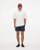 Man wearing Getrick Swim Shorts paired with a casual shirt and cap, showcasing a stylish beach look.
