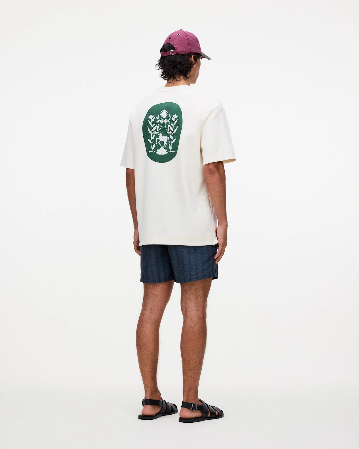 Model wearing Getrick Swim Shorts with a graphic t-shirt and cap, showcasing stylish summer attire.