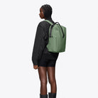 Clip Front Backpack Well Backpack worn by a model showcasing its sleek design and adjustable straps.