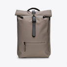 Rolltop Rucksack Cinder Backpack in grey, featuring roll-top closure and zipped front compartment.
