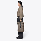 Rolltop Rucksack Cinder Backpack shown in a side view, featuring a roll-top closure and stylish design.