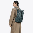 Rolltop Rucksack Mystique Backpack worn by a model in a beige coat, showcasing its waterproof design.