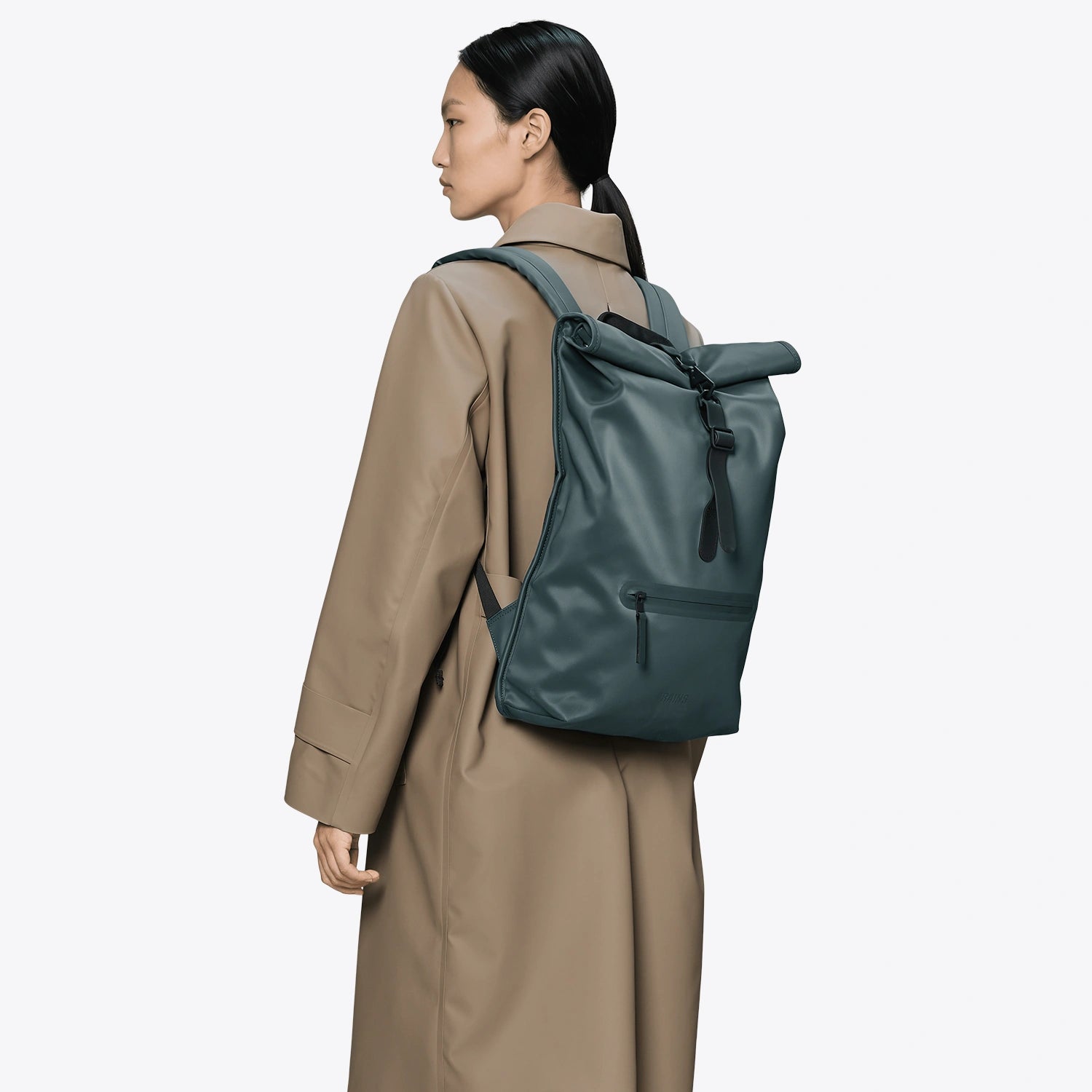 Rolltop Rucksack Mystique Backpack worn by a model in a beige coat, showcasing its waterproof design.