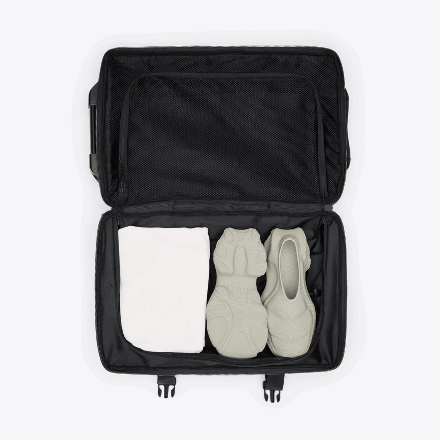Texel Cabin Bag Small Blue Dusk Suitcase opened with shoes and towel inside.