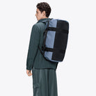 Texel Duffel Bag Small Blue Dusk Duffel Backpack worn on back of model, showcasing waterproof design and adjustable straps.