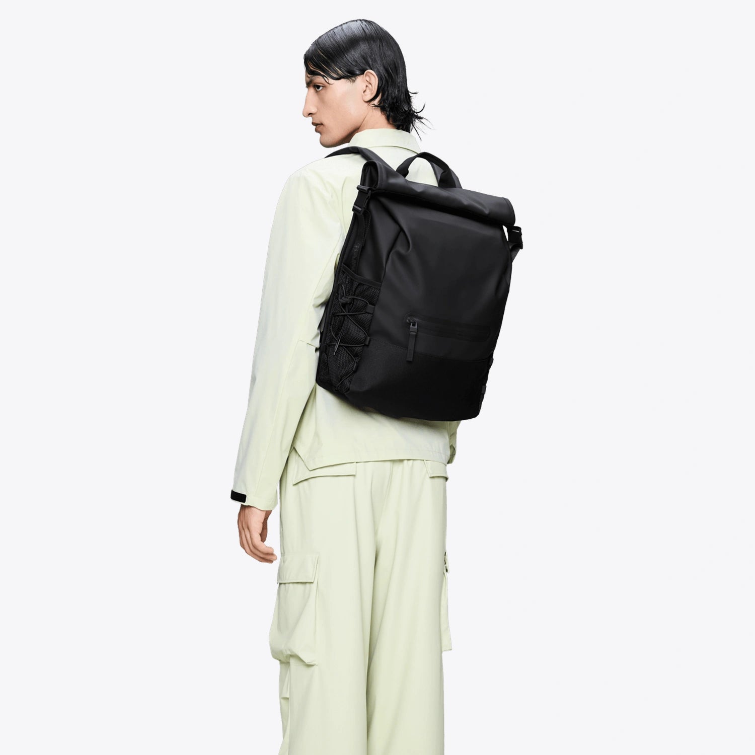 Trail Mountaineer Rolltop Black Backpack worn on a model, showcasing the roll-top design and sleek black finish.