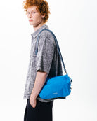 Bottle Sacoche Large Blue Check Wool Bag worn by a model, showcasing its stylish blue design and practical features.