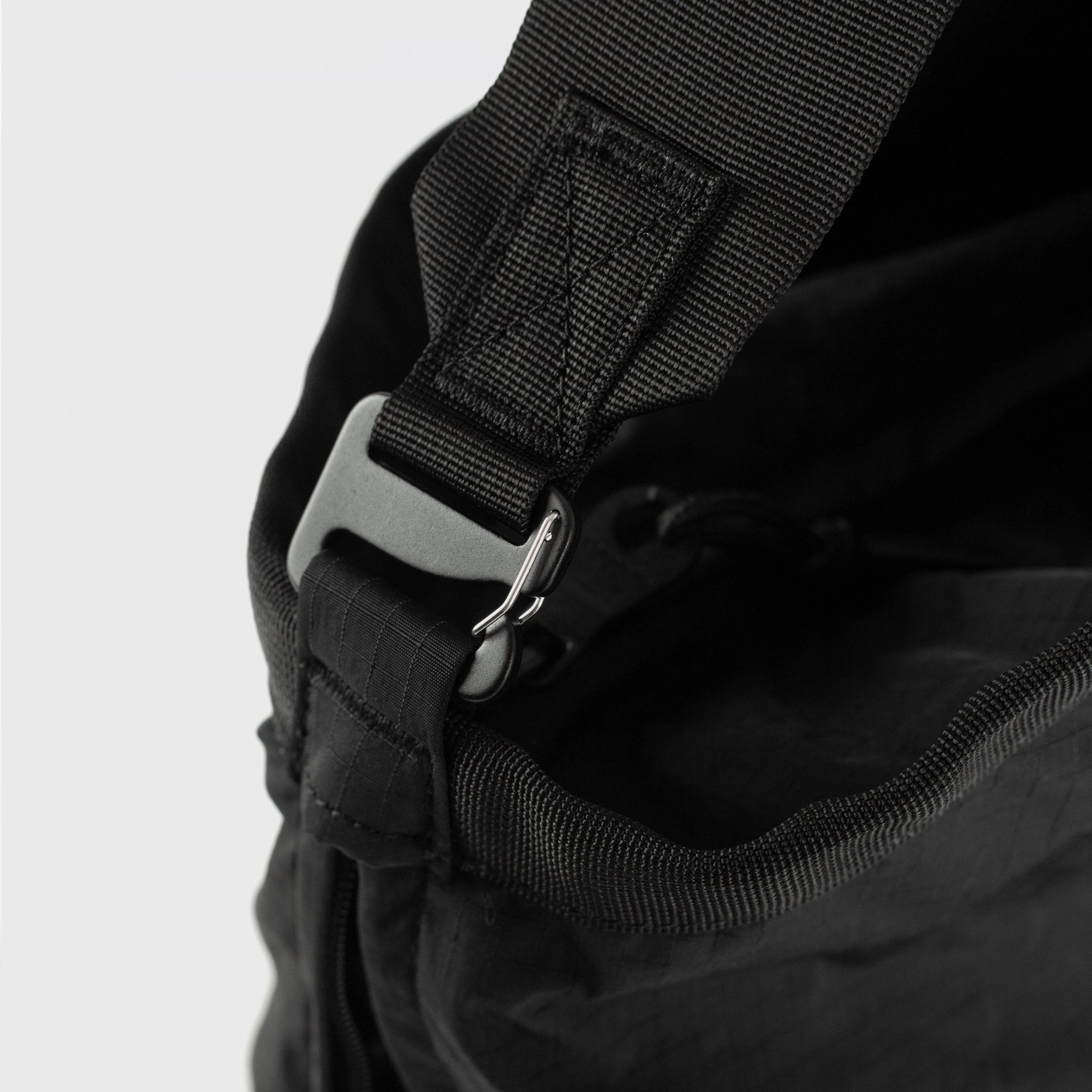 Close-up of the adjustable strap and metal buckle of the Grid Tote Bag Black Shoulder Bag.