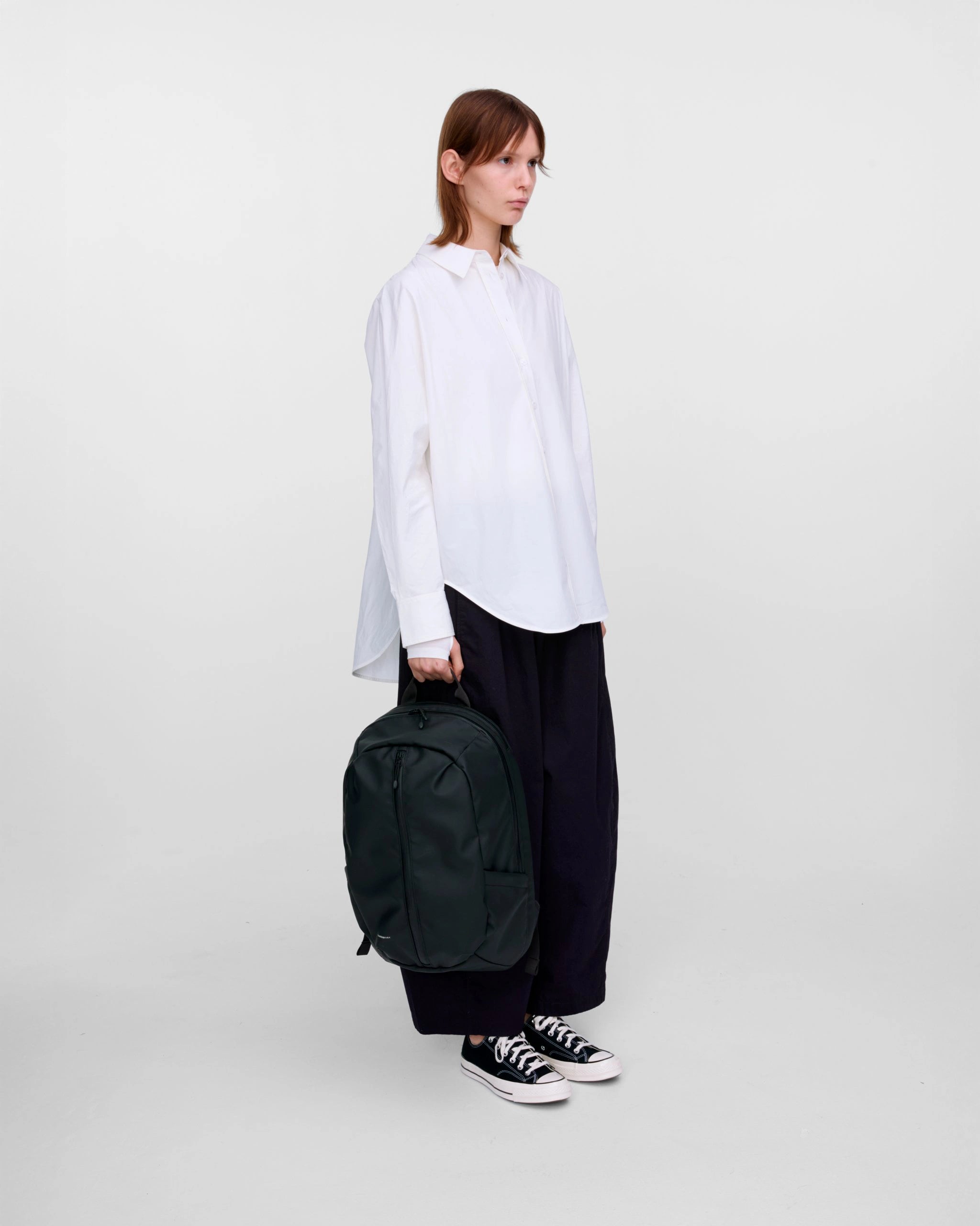 Stream Zipper Backpack Black Backpack being carried by a model in casual attire.