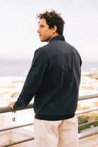 Man wearing a Campo II Navy Jacket, showcasing lightweight design and stylish fit against scenic backdrop.