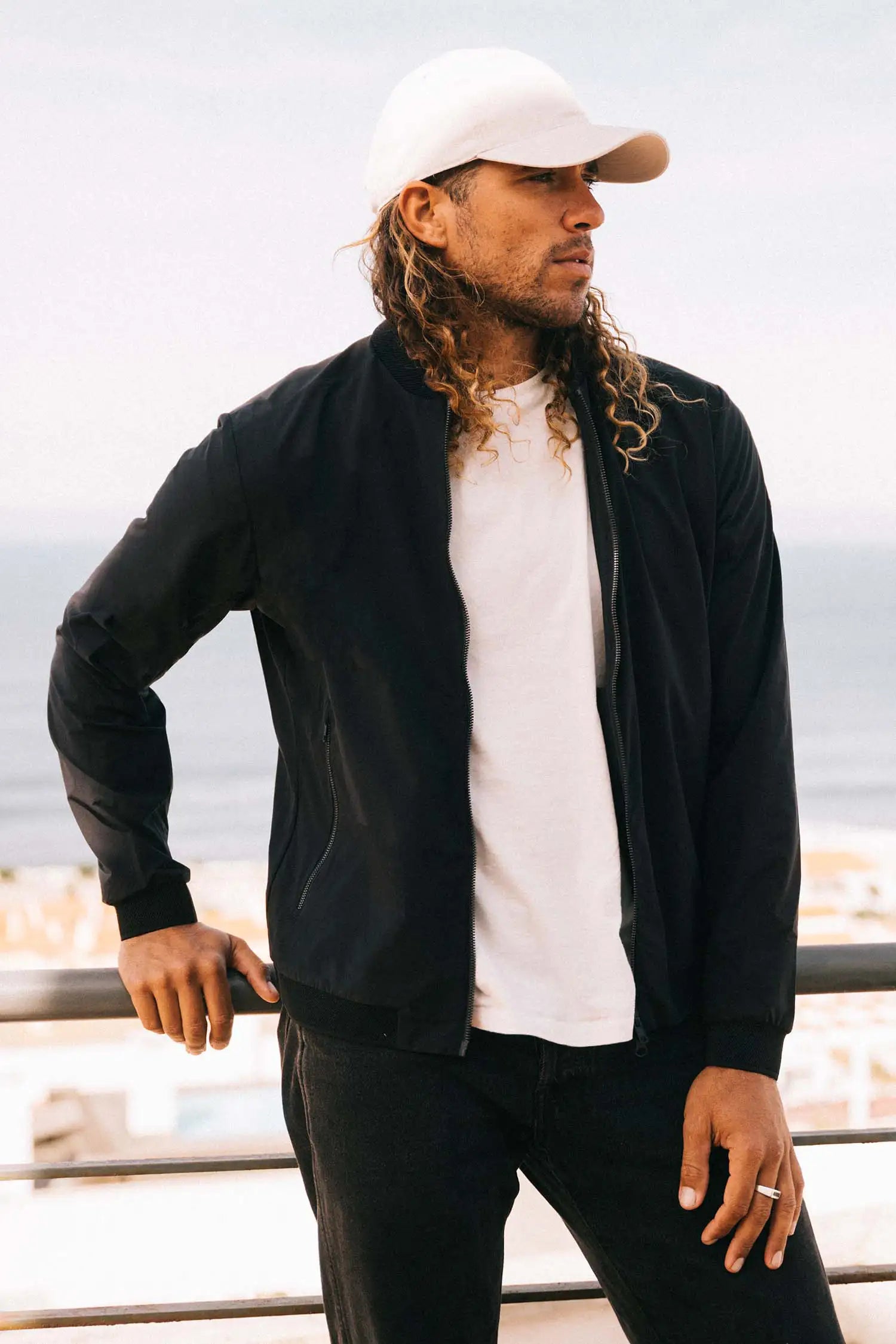 Man wearing the Campo II Graphite Jacket with a scenic coastal background.