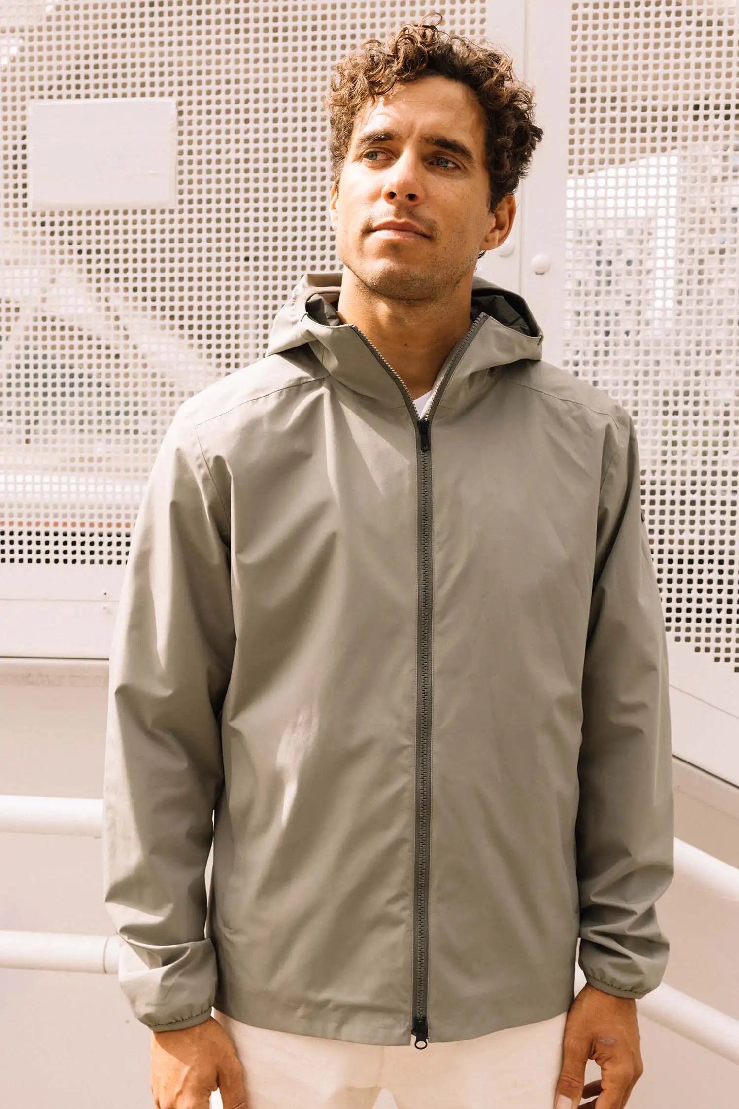 Hood II Light Green Jacket on model, showcasing its windproof and waterproof features outdoors.