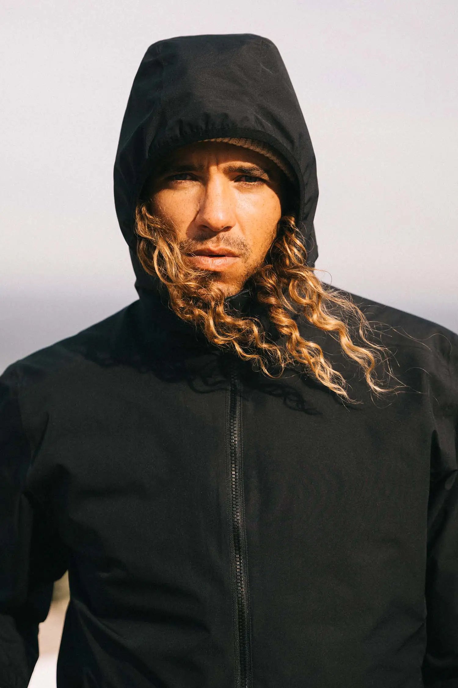 Hood II Onyx Jacket worn by a person with curly hair, ideal for spring and autumn with windproof and waterproof features.