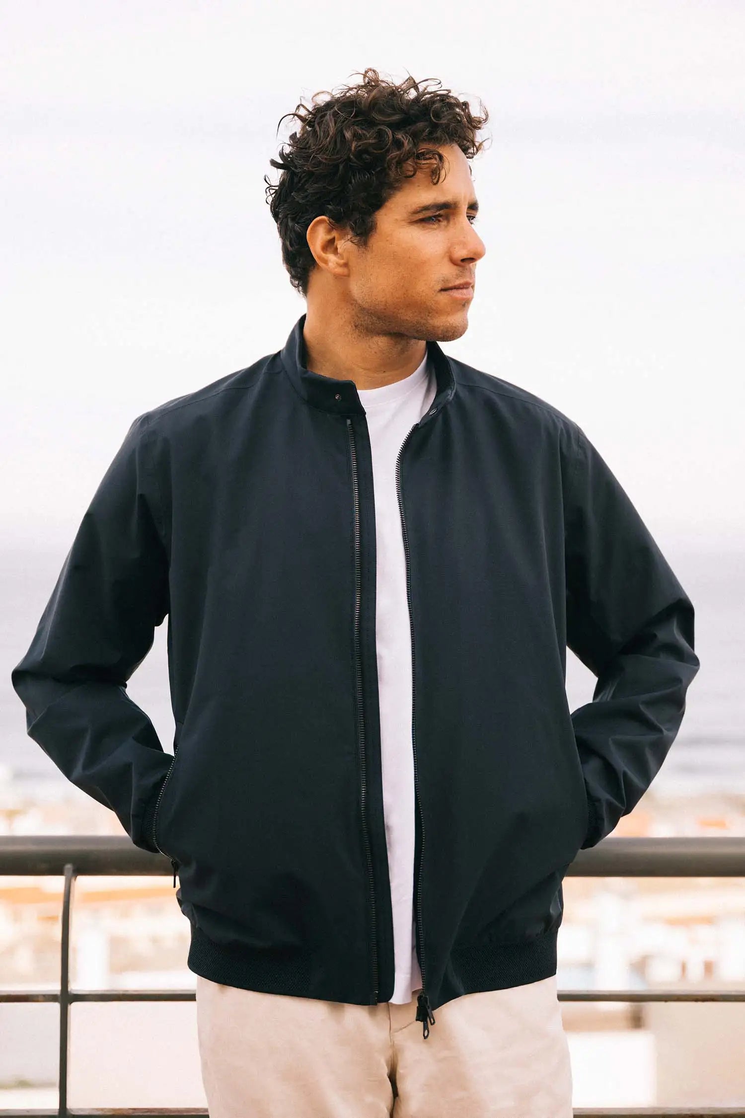 Man wearing the Plain II Midnight Jacket, a versatile windproof and waterproof summer jacket for modern style.