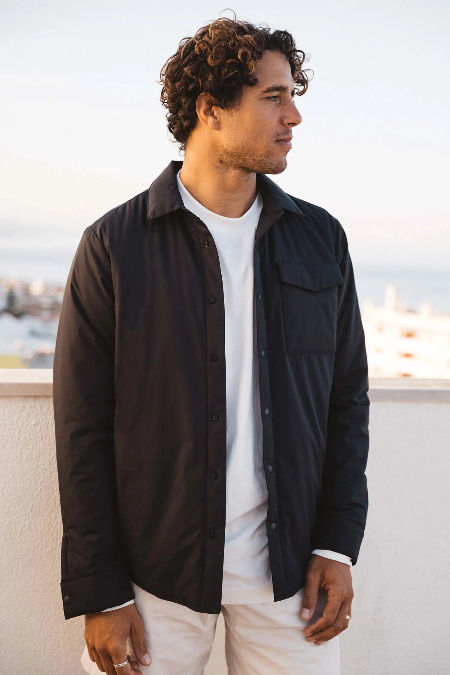 Model wearing a Trip II Graphite Overshirt in a scenic outdoor setting with a peaceful background.