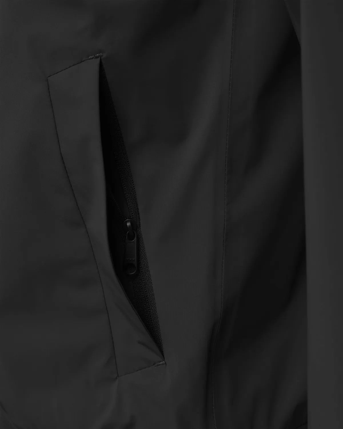 Close-up of a zippered pocket on the Era Apex Graphite Jacket, showcasing its sleek design and functionality.