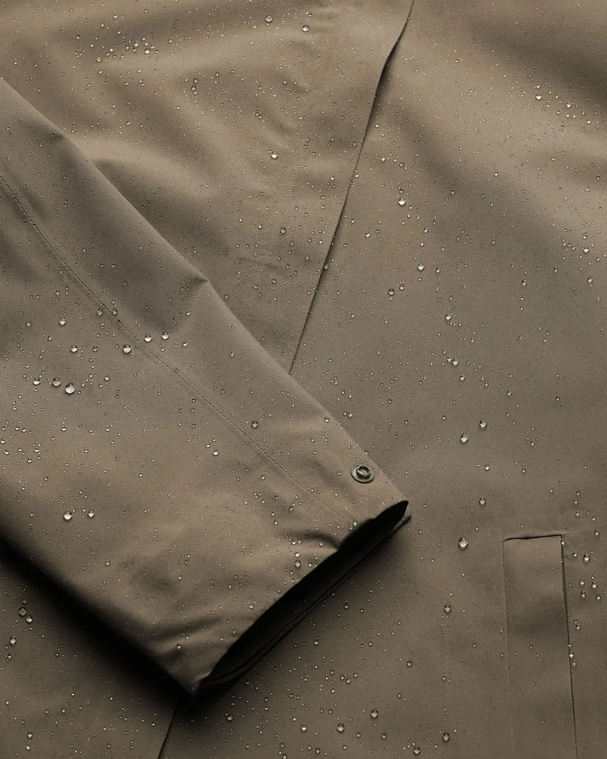 Flair II Short Cedar Jacket close-up showing water beads on windproof and waterproof fabric.