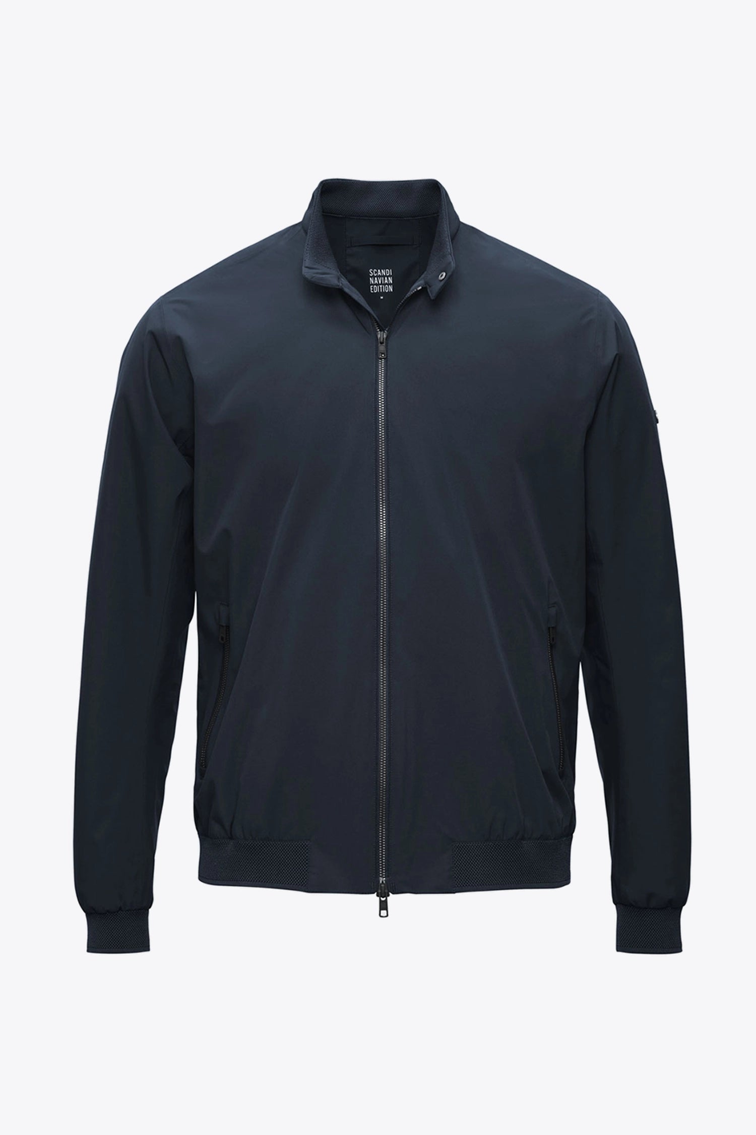 Plain II Midnight Jacket displayed in a modern city look, lightweight and waterproof, perfect for various temperatures.