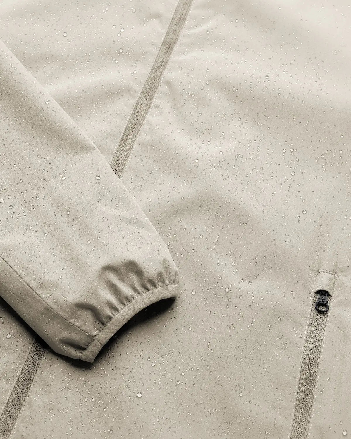 Close-up of the Veil II Khaki Jacket showing water droplets on the fabric, highlighting its waterproof feature.
