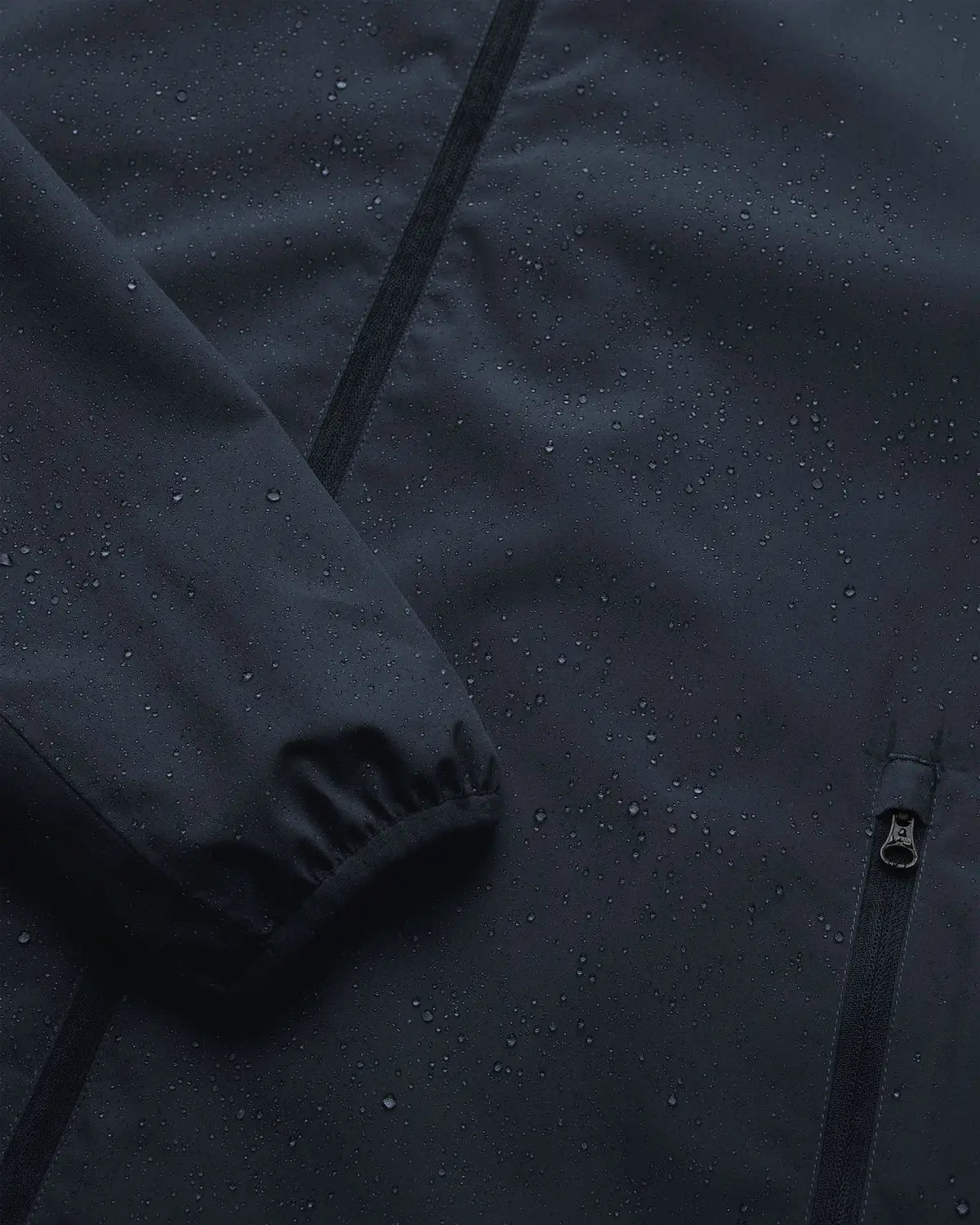 Veil II Midnight Jacket showing waterproof fabric with droplets, ideal for early spring and autumn wear.