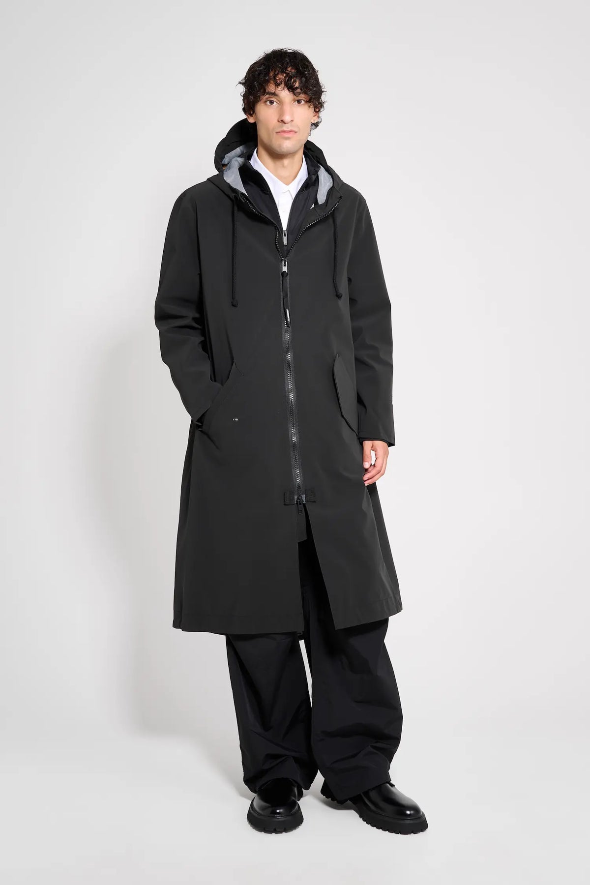 Martins Parka Black Raincoat worn by model, showcasing its long fit and adjustable hood.