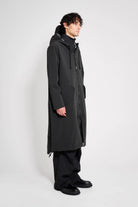 Martins Parka Black Raincoat displayed on a model, showcasing its waterproof design and adjustable features.