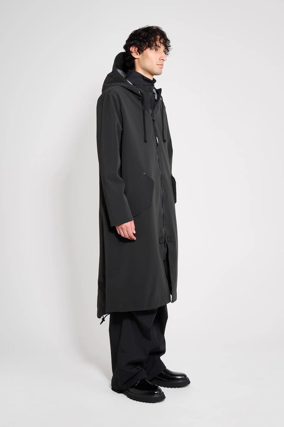Martins Parka Black Raincoat displayed on a model, showcasing its waterproof design and adjustable features.