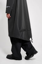 Martins Parka Black Raincoat shown on a man walking, highlighting the long fishtail design and waterproof fabric.