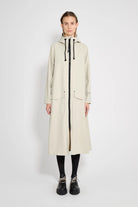 Mosebacke Long Patch Pelican Raincoat on a model showcasing its A-line silhouette and adjustable hood.