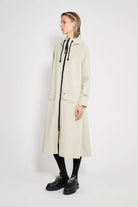Mosebacke Long Patch Pelican Raincoat displayed on a model, showcasing its A-line silhouette and waterproof design.