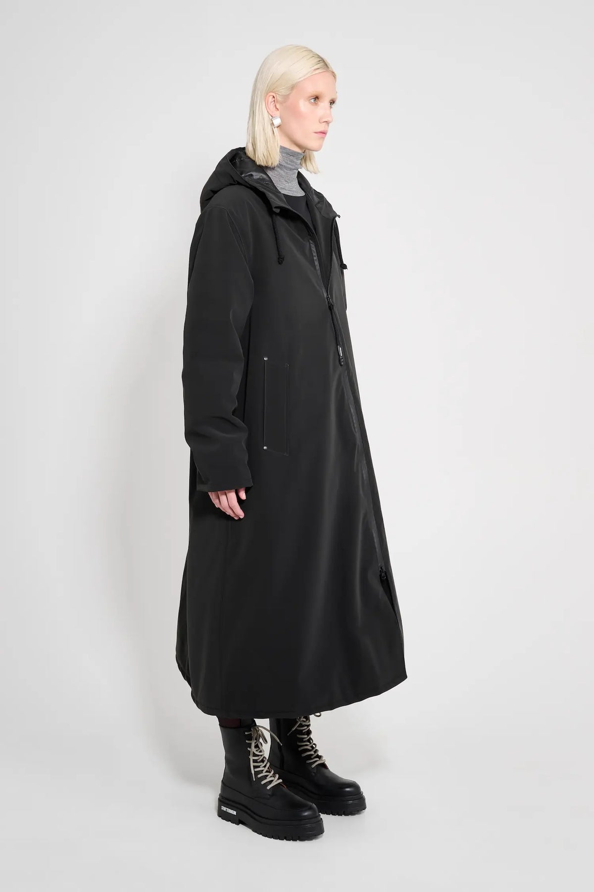 Mosebacke Long Matte Black Winter Coat displayed on a model, showcasing its A-line silhouette and adjustable hood.