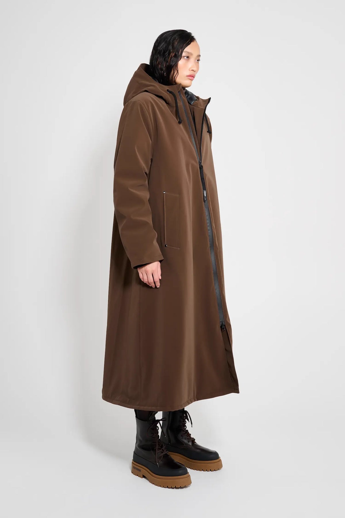 Mosebacke Long Matte Dark Brown Winter Coat on a model, showcasing its adjustable hood and A-line silhouette.