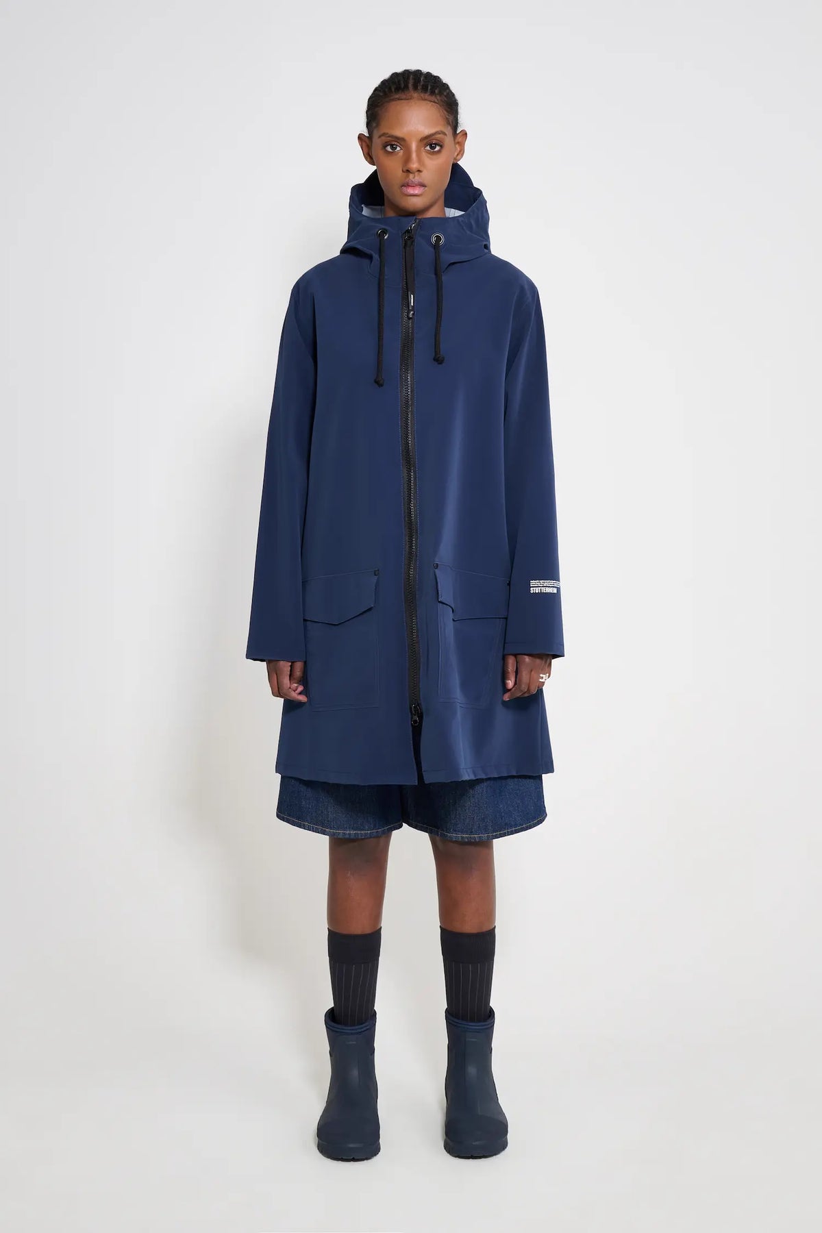 Mosebacke Patch Navy Raincoat displayed on model, featuring adjustable hood and waterproof design.