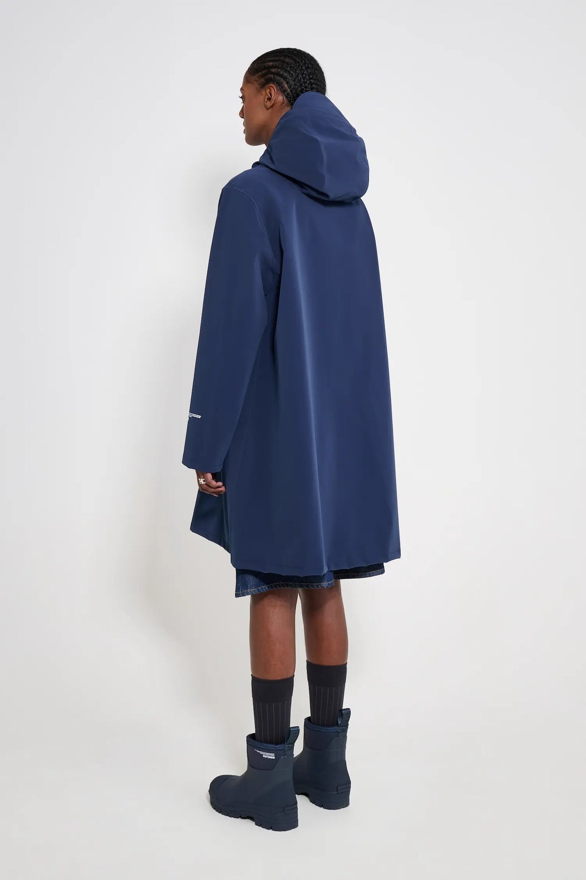 Mosebacke Patch Navy Raincoat displayed from the back, highlighting its A-line silhouette and adjustable hood.