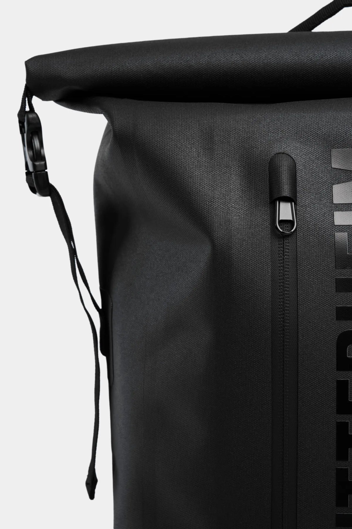 Close-up of Rain Rolltop 25L Black Backpack showing waterproof zipper and rolltop design.