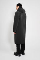 Model showcasing the Stockholm Long Matte Black Winter Coat from the back, highlighting the adjustable hood.