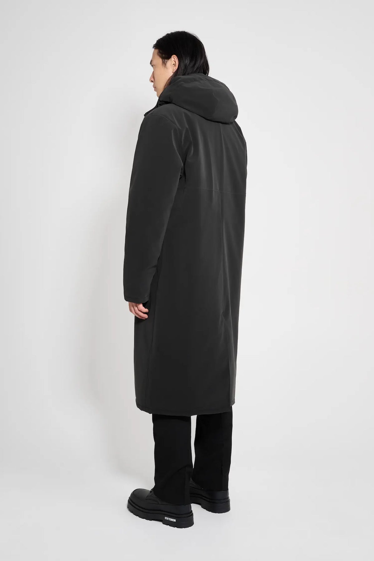Model showcasing the Stockholm Long Matte Black Winter Coat from the back, highlighting the adjustable hood.