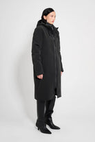 Stockholm Long Matte Black Winter Coat displayed on a model, showcasing its oversized fit and adjustable hood.