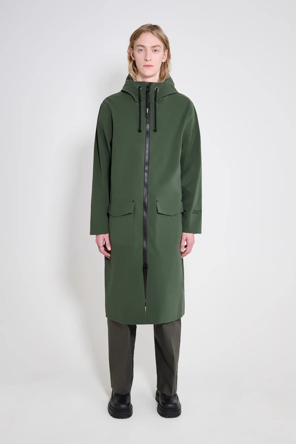 Stockholm Long Patch Matte Green Raincoat displayed on a model, showcasing its oversized fit and waterproof design.