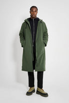 Stockholm Long Matte Green Winter Coat model wearing oversized fit with adjustable hood and fleece-lined pockets.