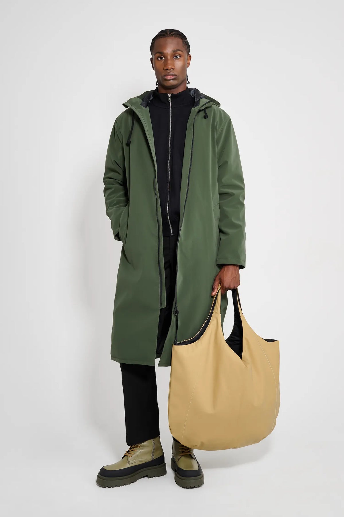 Model wearing the Stockholm Long Matte Green Winter Coat with a beige tote bag.