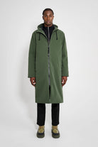 A model wearing the Stockholm Long Matte Green Winter Coat featuring a straight oversized fit and adjustable hood.