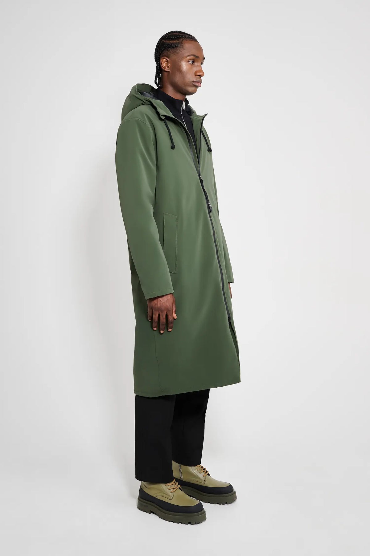 Stockholm Long Matte Green Winter Coat worn by a model, showcasing its sleek design and adjustable hood.