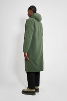 Stockholm Long Matte Green Winter Coat displayed on model from the back, showcasing its oversized fit and adjustable hood.