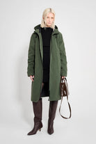 Stockholm Long Matte Green Winter Coat worn by a model, showcasing its oversized fit and adjustable hood.