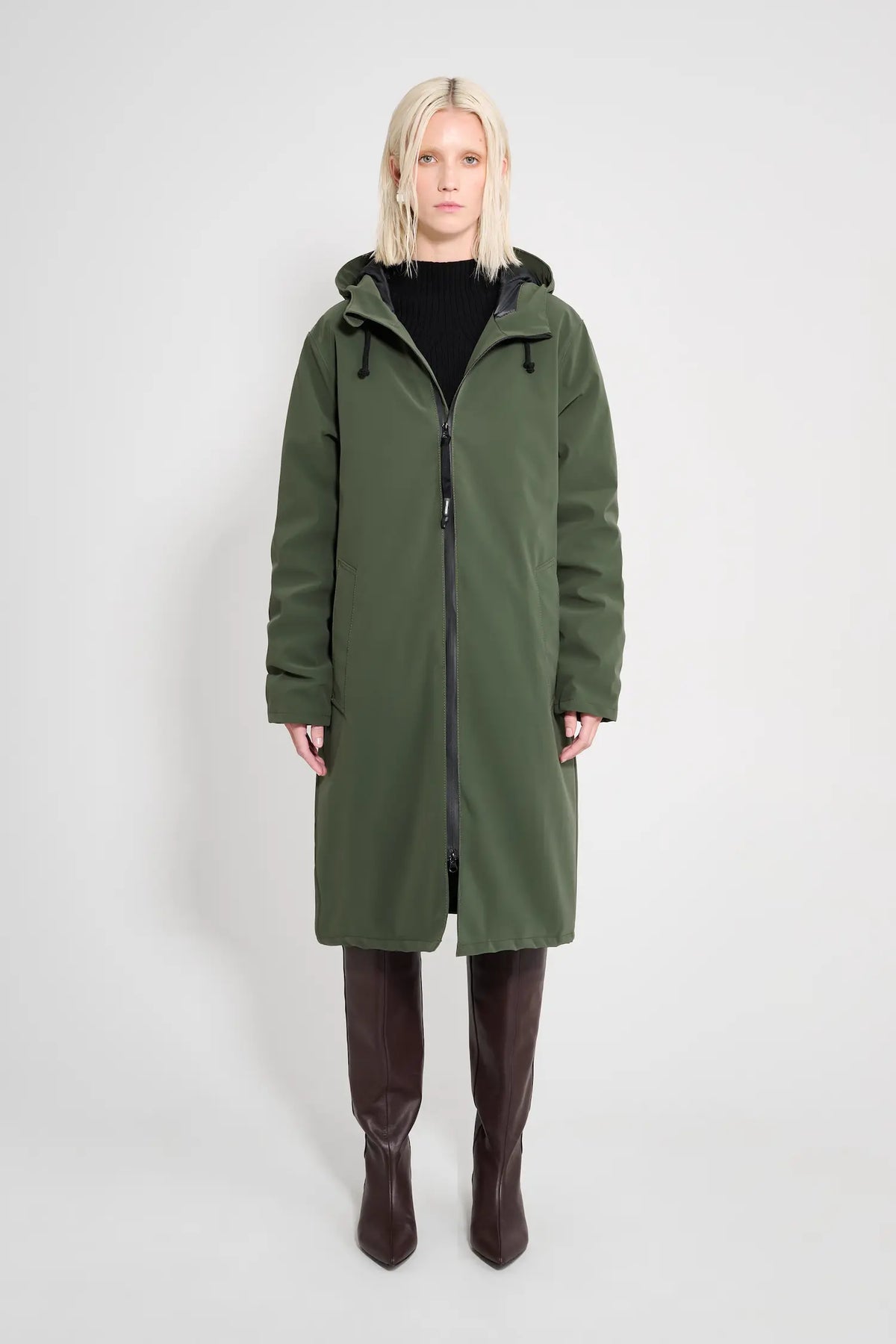 Stockholm Long Matte Green Winter Coat on model featuring a hood and zip closure.