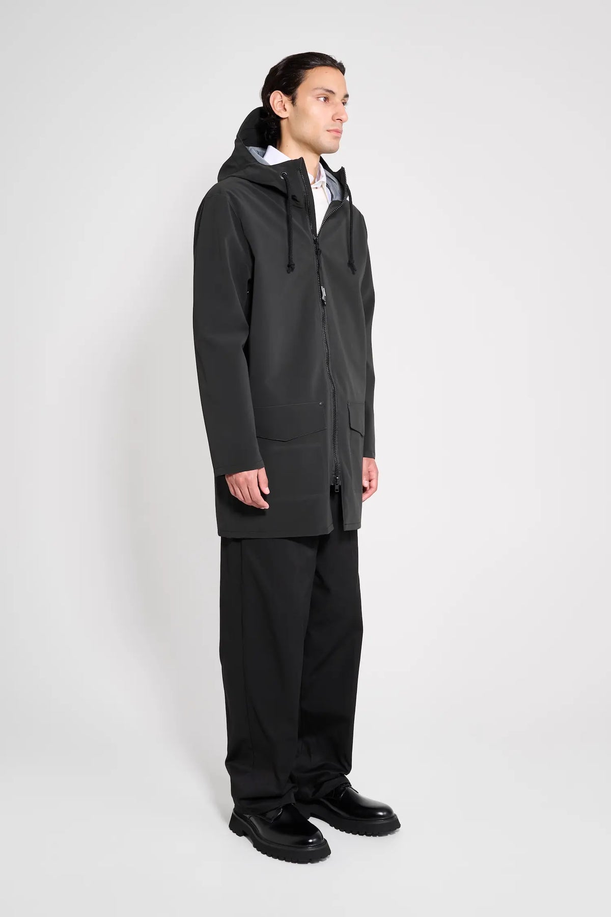 Stockholm Patch Black Raincoat on model showcasing oversized fit and adjustable hood in black.